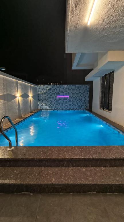 a large swimming pool with blue water in a building at Mist Villa in Igatpuri