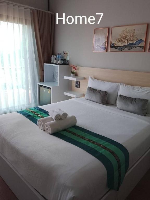 a bedroom with a large bed with towels on it at Two Tree Cafe At Suanmuangthong in Ban Chi Noi