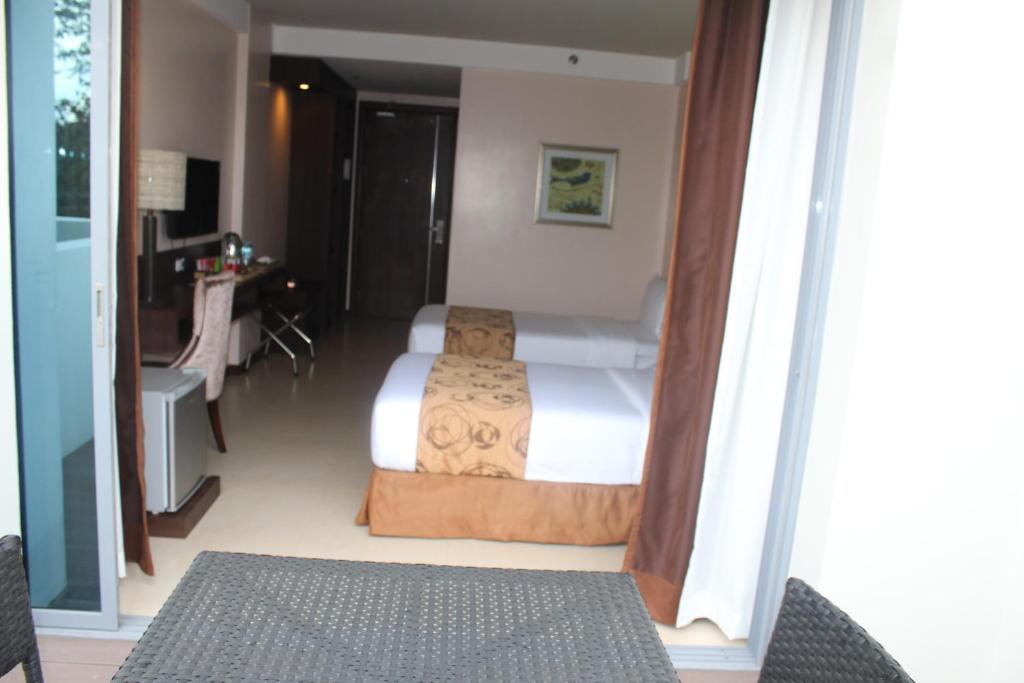 Postel nebo postele na pokoji v ubytování Kew Hotel Tagbilaran