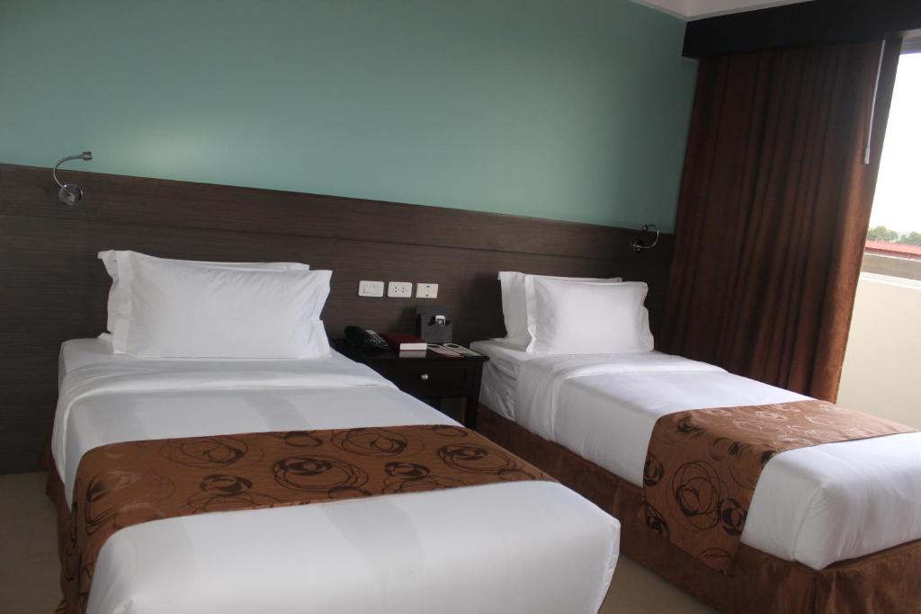 Postel nebo postele na pokoji v ubytování Kew Hotel Tagbilaran
