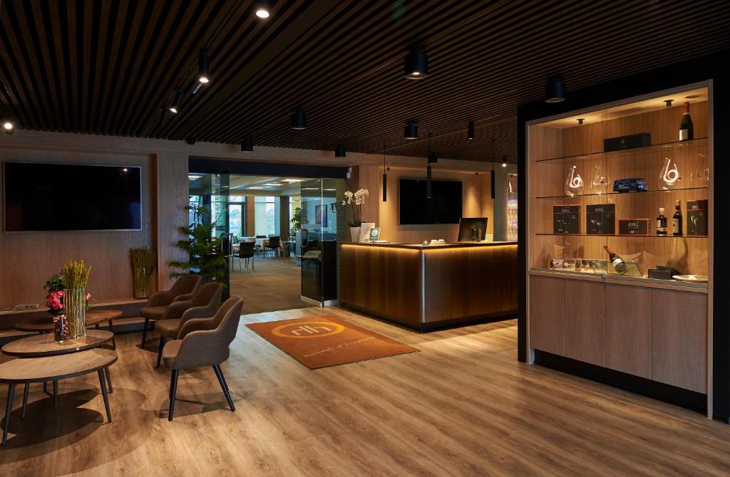 a lobby with a table and chairs and a bar at Hotel Hedegaarden in Vejle
