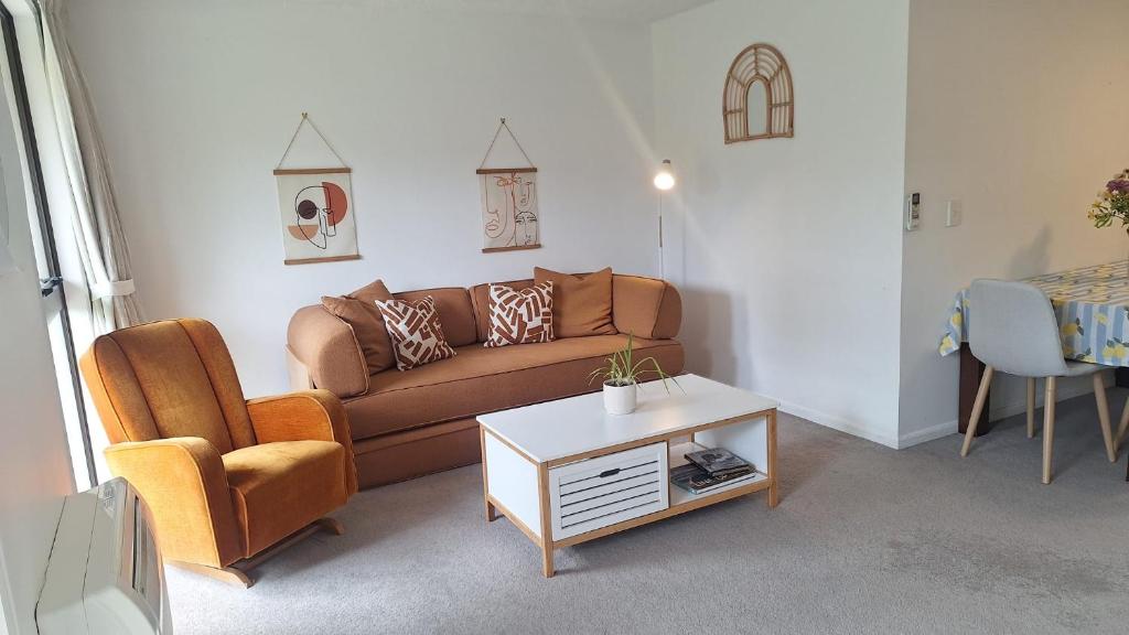 a living room with a couch and a table at Relax on Robertson in Queenstown