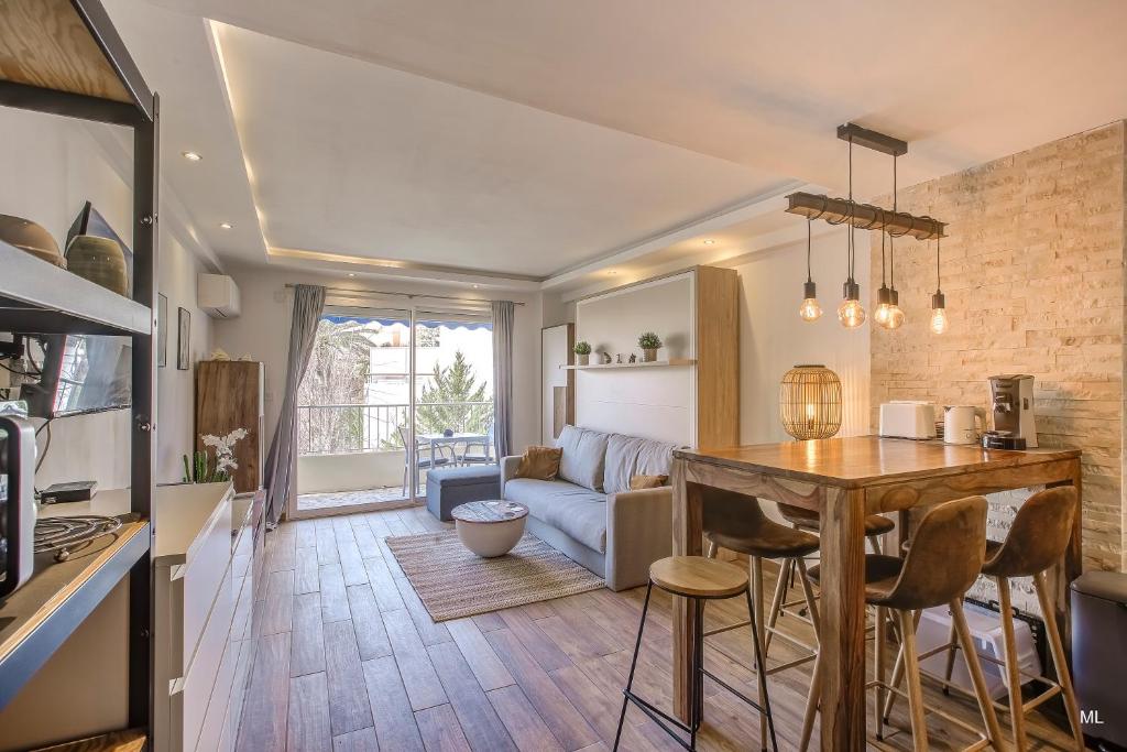 a kitchen and living room with a table and a couch at WIlson Palace - Studio avec terrasse et climatisation in Antibes