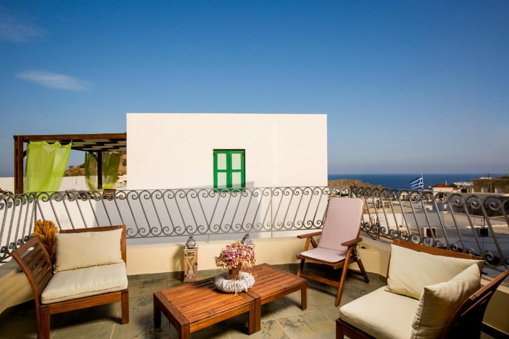 a balcony with chairs and a table and the ocean at Lindos Villa Estelle in Líndos