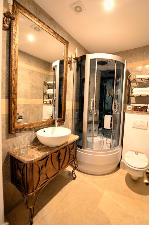 a bathroom with a sink and a mirror and a toilet at Castel Transilvania in Baia Mare