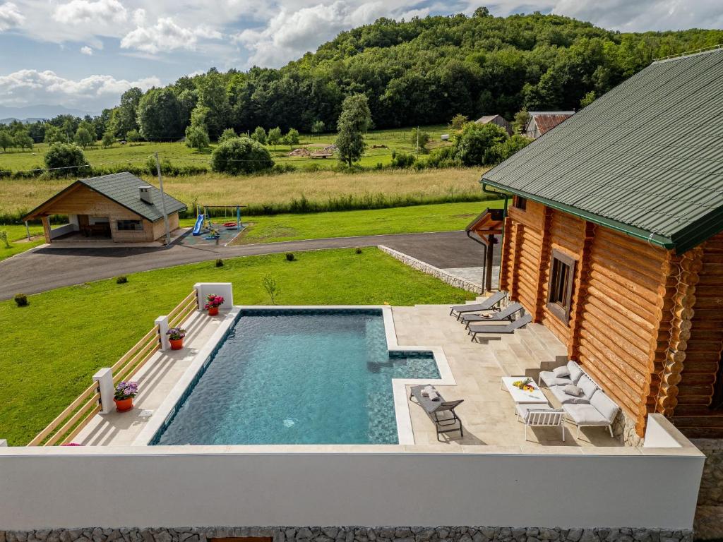 an overhead view of a swimming pool next to a house at Log Cabin Valley - Private Villa with Pool in Gospić