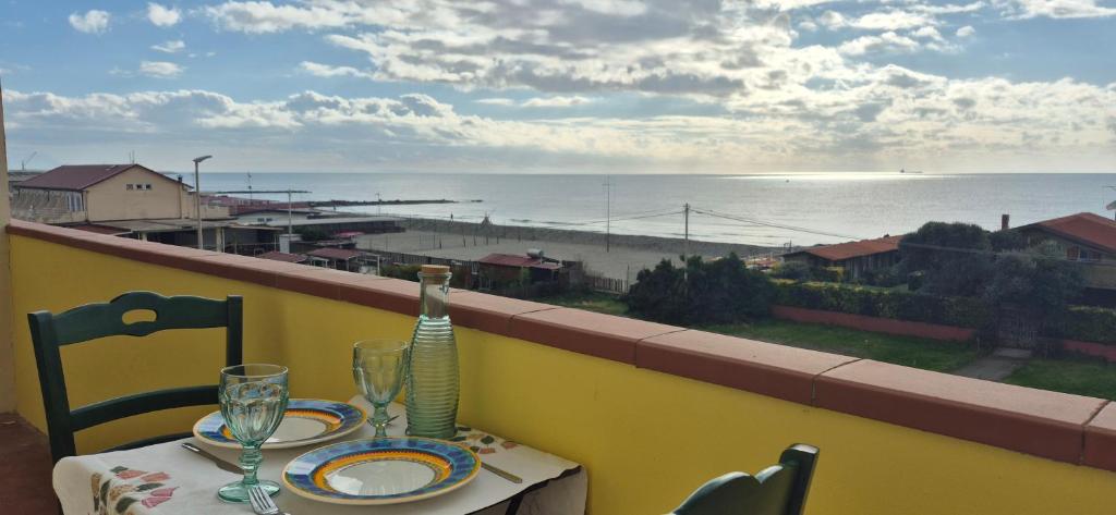 a table on a balcony with a view of the beach at Eremare Marinella in Marinella di Sarzana
