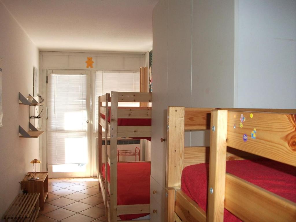 a bedroom with two bunk beds and a room with a window at Cervinia Apartments in Breuil-Cervinia