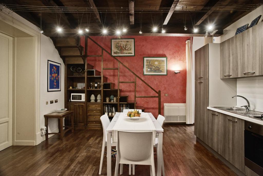 een keuken met een witte tafel en een rode muur bij Trilocale al Politeama - Zyz in Palermo