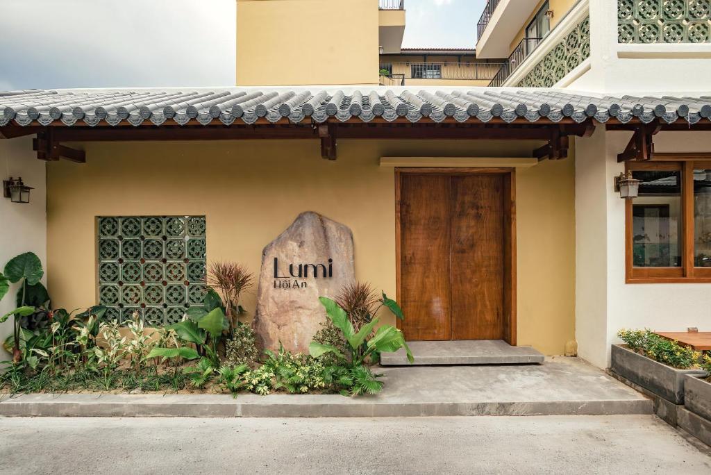 a front door of a house with a sign on it at Lumi Hội An Hotel in Hoi An