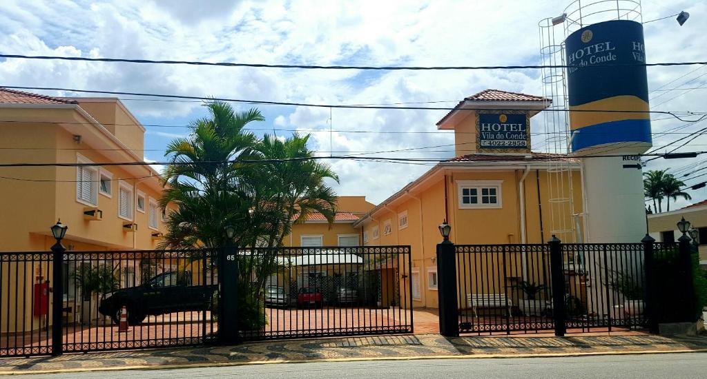 une clôture noire devant un bâtiment avec une tour dans l'établissement Hotel Vila do Conde, à Itu