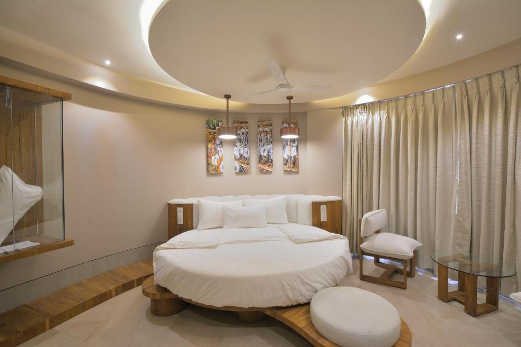 a bedroom with a bed and a table and a chair at Urbane The Hotel in Ahmedabad