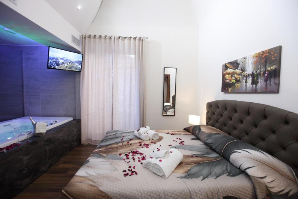 a bedroom with a bed and a tub with confetti at Premiere Luxury Catania in Catania