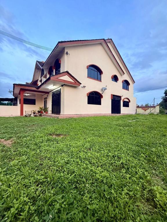 a house with a green field in front of it at De'Lunar Homestay in Johor Bahru