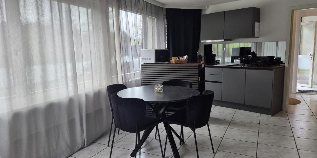 a kitchen with a table and chairs in a room at Moderne Gästesuite in Lucerne