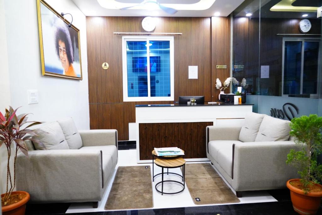 a living room with two couches and a table at Deva Towers in Puttaparthi