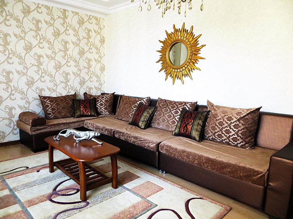 a living room with a brown couch and a mirror at Best-BishkekCity Apartments 2 in Bishkek