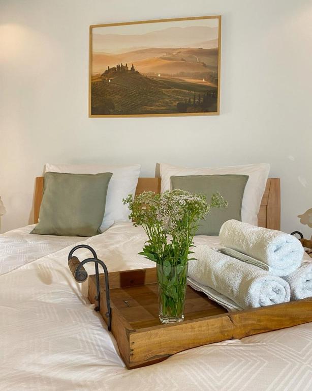 a bed with a wooden tray with towels and a vase on it at Auszeit Ferienhaus Nr 2 und 2a in Sierscheid
