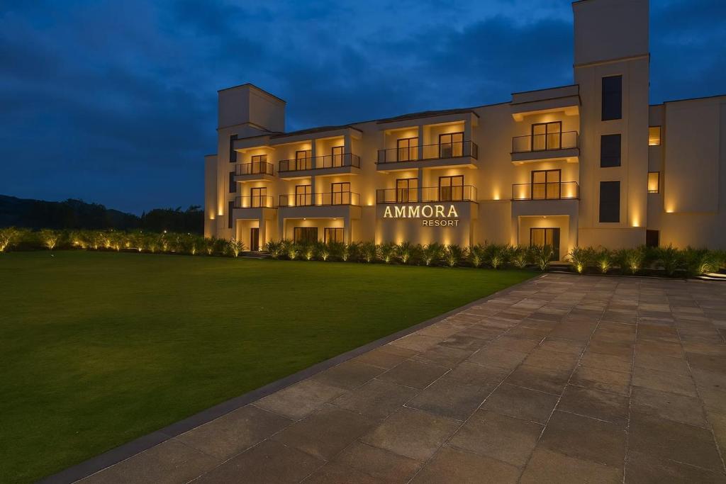 a building with a lawn in front of it at Ammora Resort in Kārli