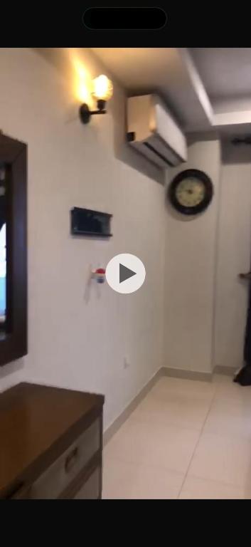 a room with a clock on a white wall at Luxury Aparment in Islamabad