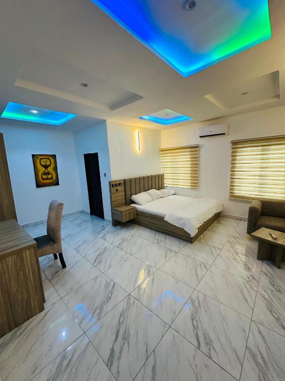 ein Schlafzimmer mit einem Bett, einer Couch und einem Tisch in der Unterkunft Stan - Haven Apartments ASOKORO in Asokoro
