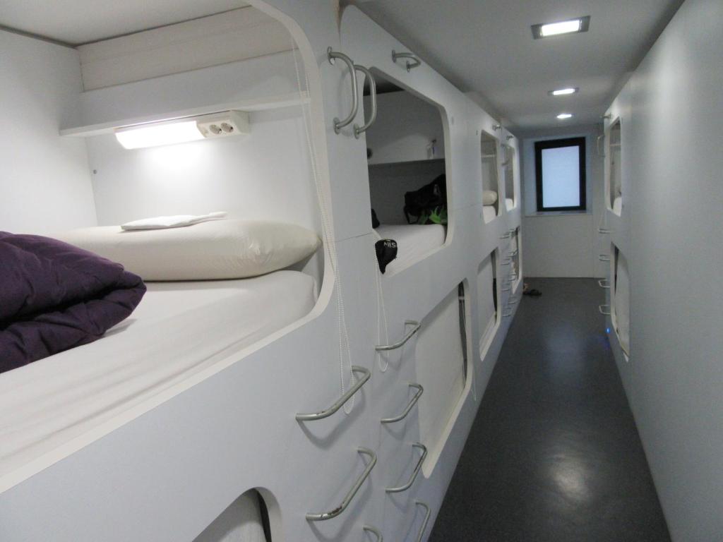 Cette petite chambre comprend deux lits et un couloir. dans l'établissement Hostel Casa Ibarrola, à Pampelune