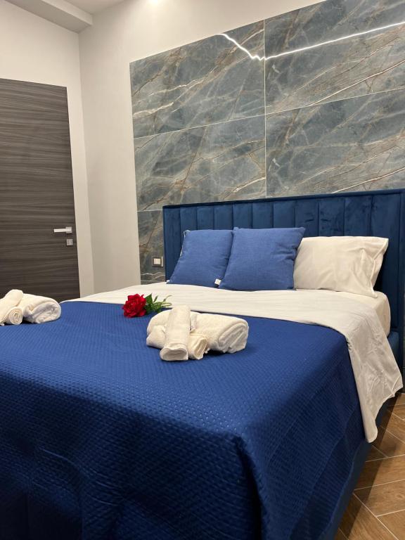 a blue and white bed with two towels on it at Domus Anna in Bacoli