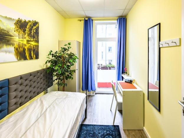 a bedroom with a bed and a desk and a window at Attic apartment in villa! in Berlin