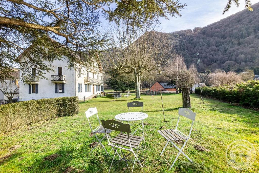 a table and chairs in the yard of a house at Aubépine in Cadéac