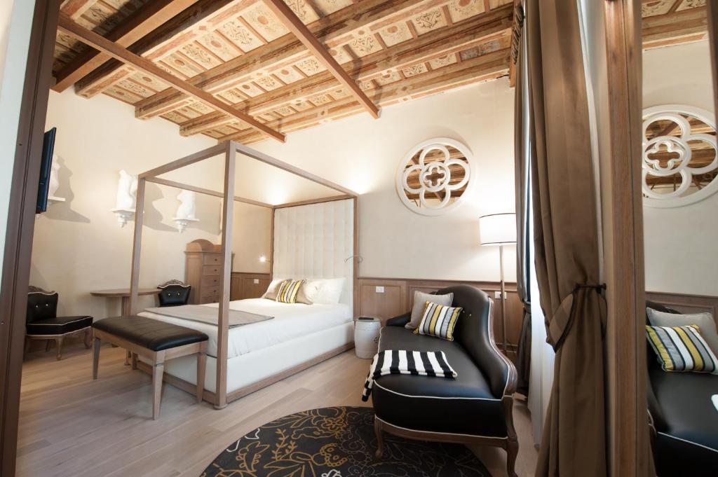 a bedroom with a bed and a couch and a chair at Residenza Bonifacio - Adults Only in Verona