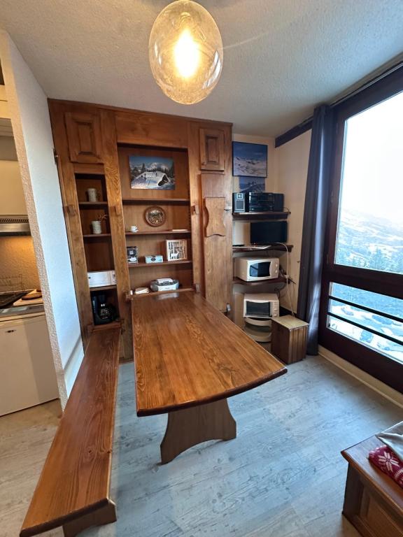 a large wooden table in a kitchen with a window at Studio cosy 4 pers, à APOLLO - Pied des pistes - SkiOpied, Casier à skis - Parking Gratuit - Domaine des Sybelles in Villarembert
