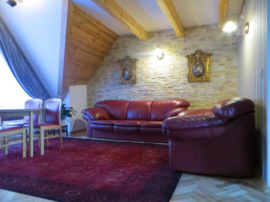 a living room with a leather couch and a table at Residenz Polenia in Zakopane