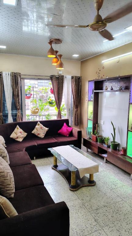 a living room with a couch and a table at Gem Backpackers hostel in Siliguri