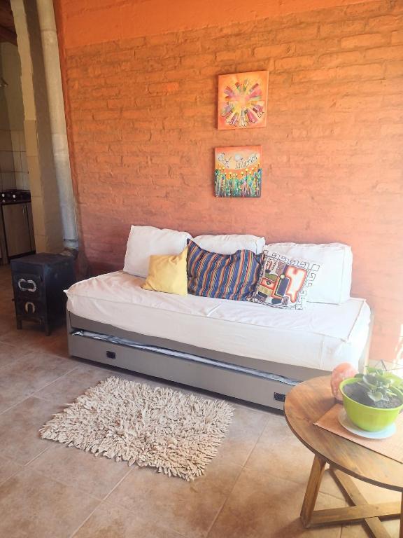 a couch with pillows on it in a room at Casa Munay para dos personas in Uspallata