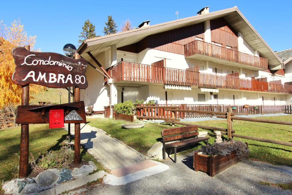 un bâtiment avec un panneau devant lui dans l'établissement Hostdomus - Bi Level Apartment, à Pragelato