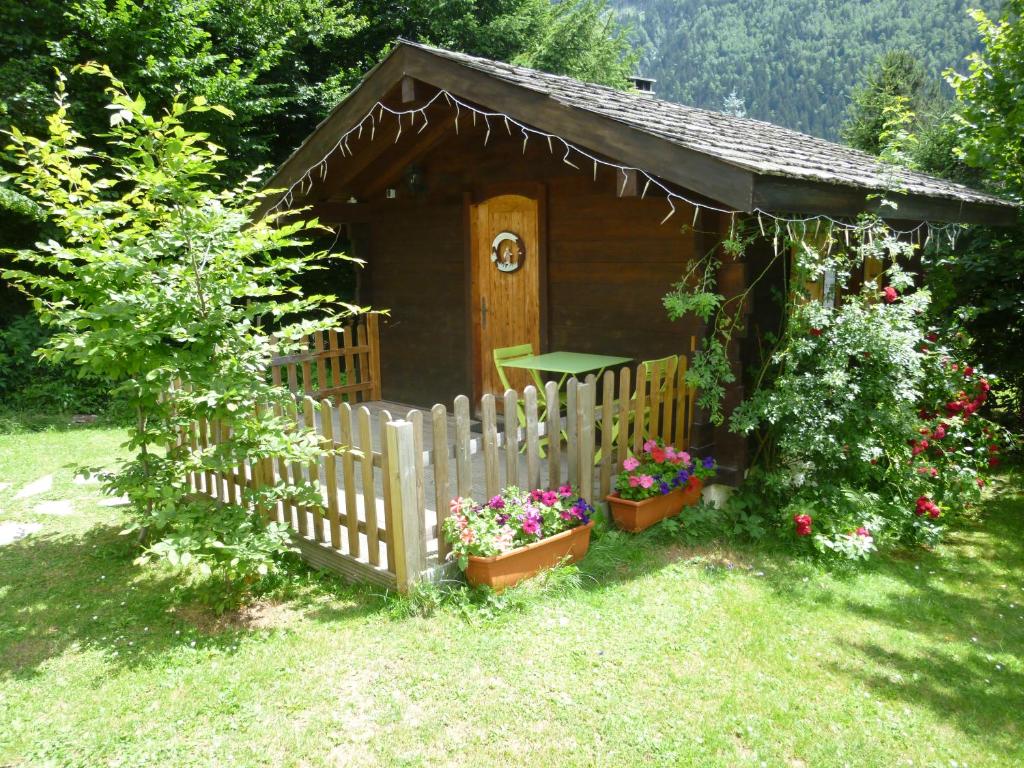 a small wooden cabin with flowers in a yard at Chalet Alpine Rose in Chamonix