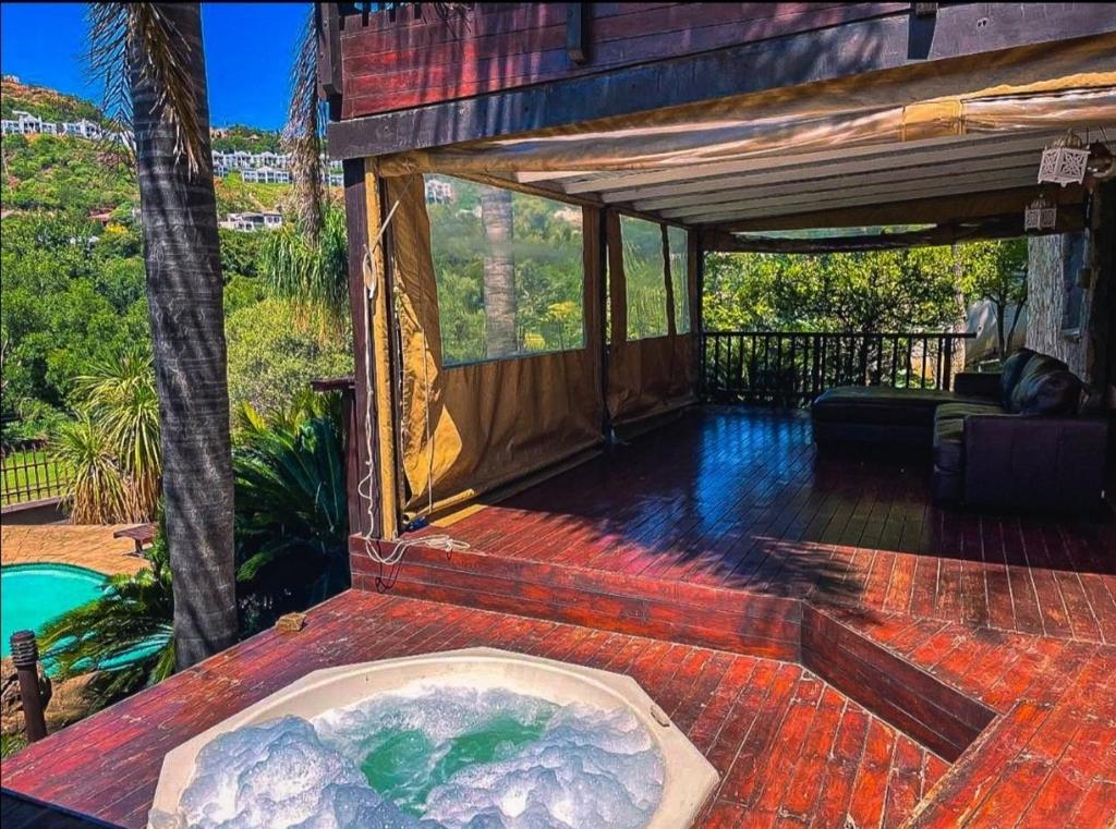 a hot tub on the deck of a house at Studio APT with pool and jacuzzi at the golf course in Johannesburg