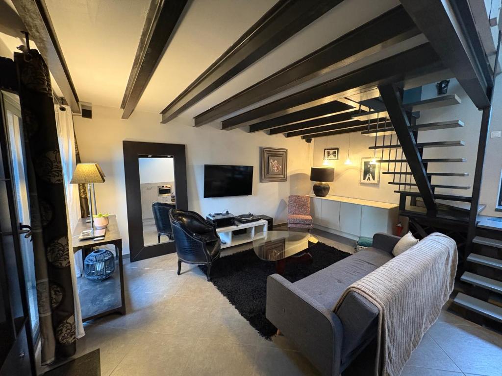 a living room with a couch and a table at Les lauriers du loft in Pazayac