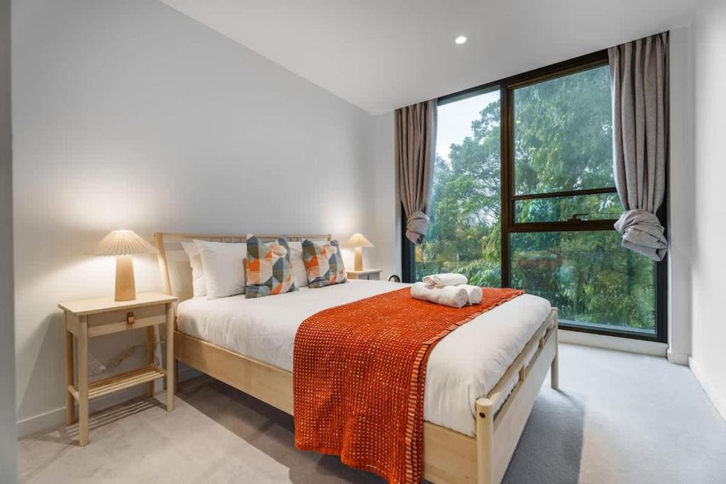 a bedroom with a bed and a large window at Premium South Melb 2 Queens Study Pool & Gym in Melbourne