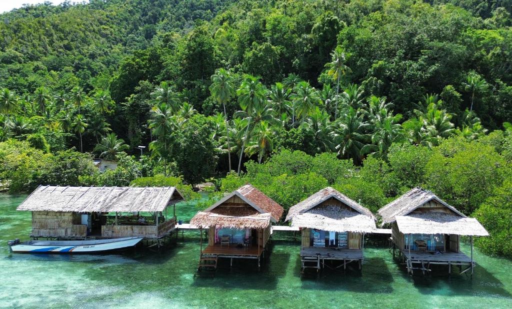 an aerial view of a group of huts in the water at Seahorse Homestay in Pulau Mansuar