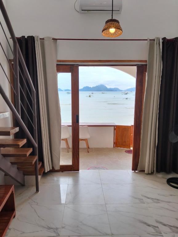 a living room with a view of the ocean at Alfa Beachfront Lofts in El Nido