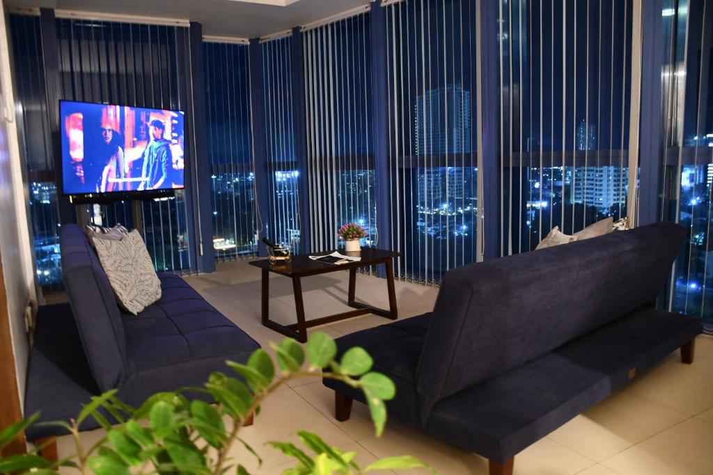 a living room with a couch and a flat screen tv at The City Escape in Cebu City