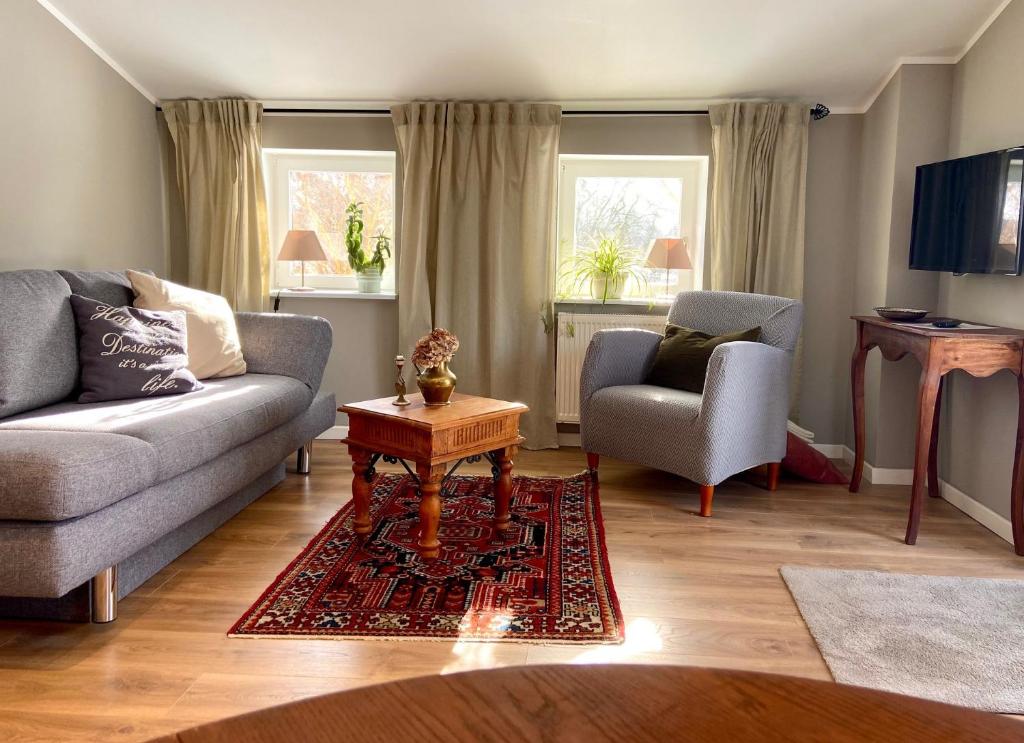 a living room with a couch and a chair and a table at Ferienwohnung an der Schlei oben in Fleckeby