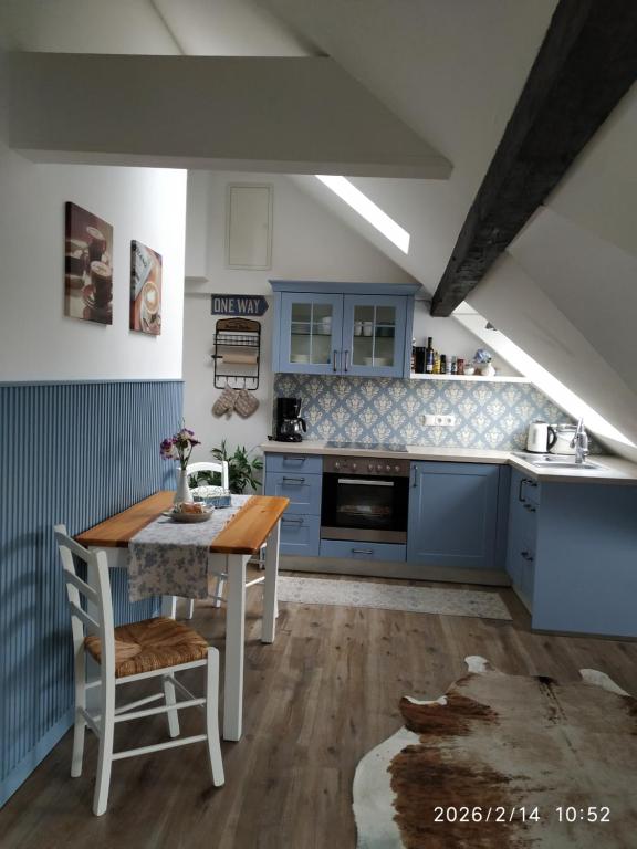 a kitchen with blue cabinets and a wooden table at Ferienwohnung Luna in Trier