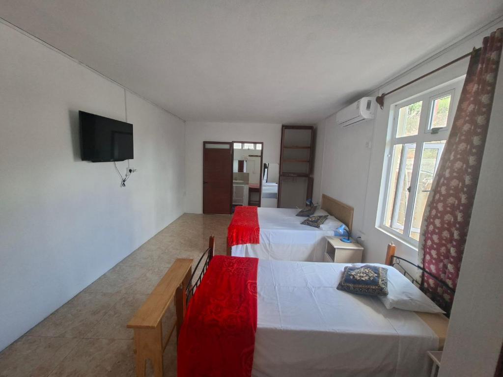 a room with two beds and a television in it at Belle terre sur mer in La Ferme