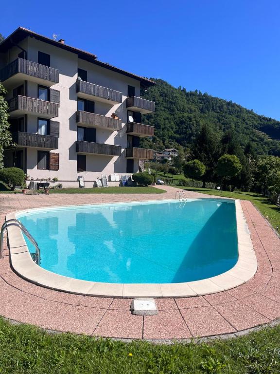 a large swimming pool in front of a building at Appartamento Levico lake in Levico Terme