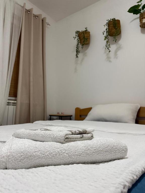 two beds with towels on them in a bedroom at Barbello in Stara Pazova