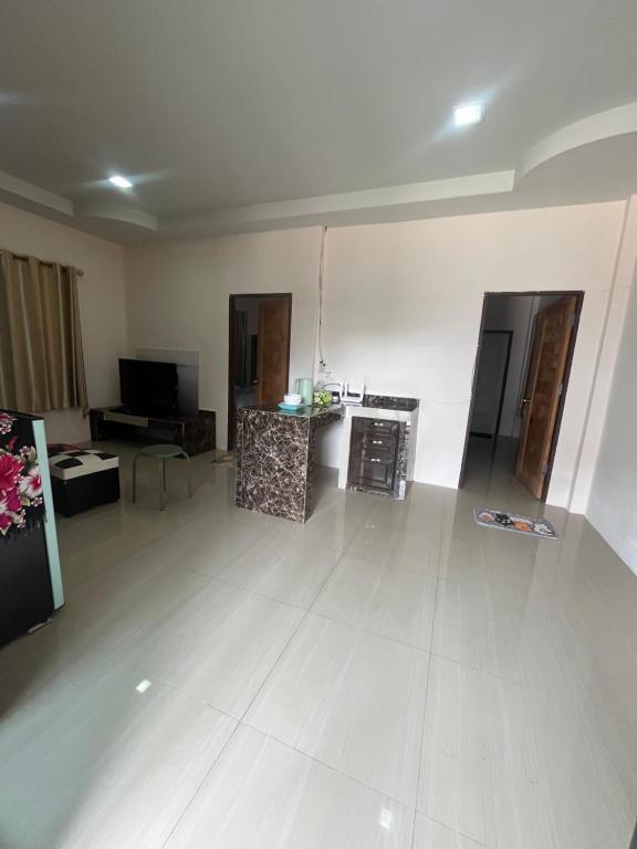 a large living room with a white floor and a tv at ใบไม้ in Ko Si Chang