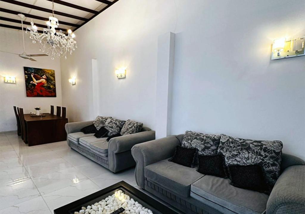 a living room with two couches and a table at Cactus Boralesgamuwa in Boralesgamuwa