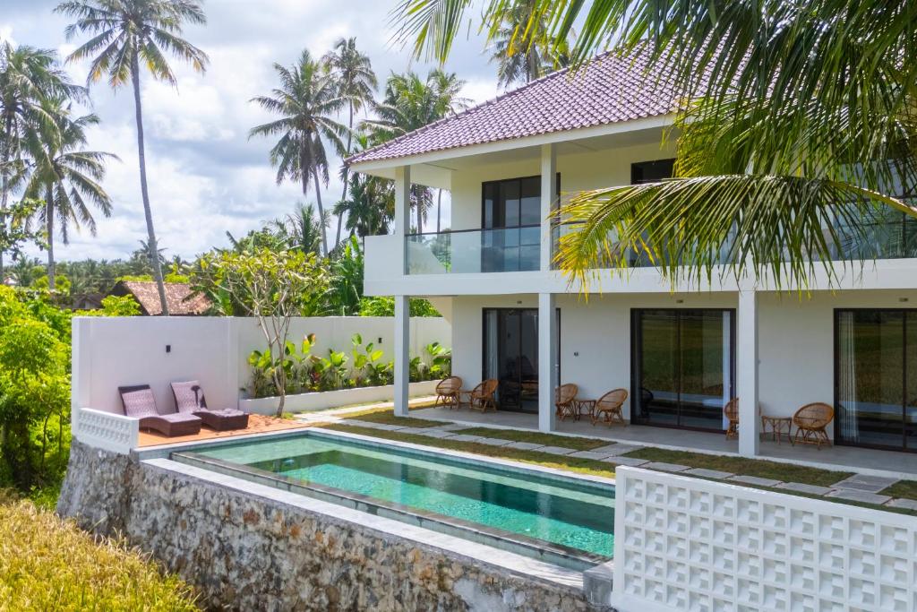 eine Villa mit Swimmingpool und einem Haus in der Unterkunft Leafy's Lodge in Padangnegeri
